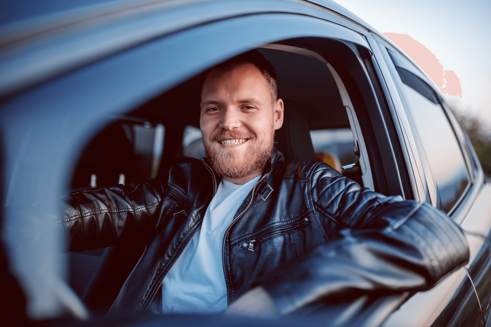 smiling man driving a car